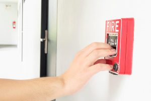 man-is-reaching-his-hand-push-fire-alarm-hand-station